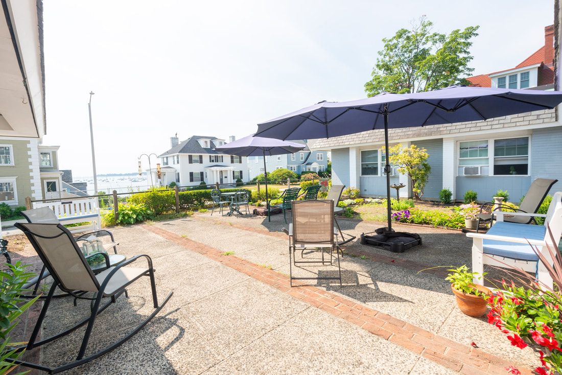Photo of the front courtyard of the Girdler house, overlooking large houses across the way with a view of the ocean between them.